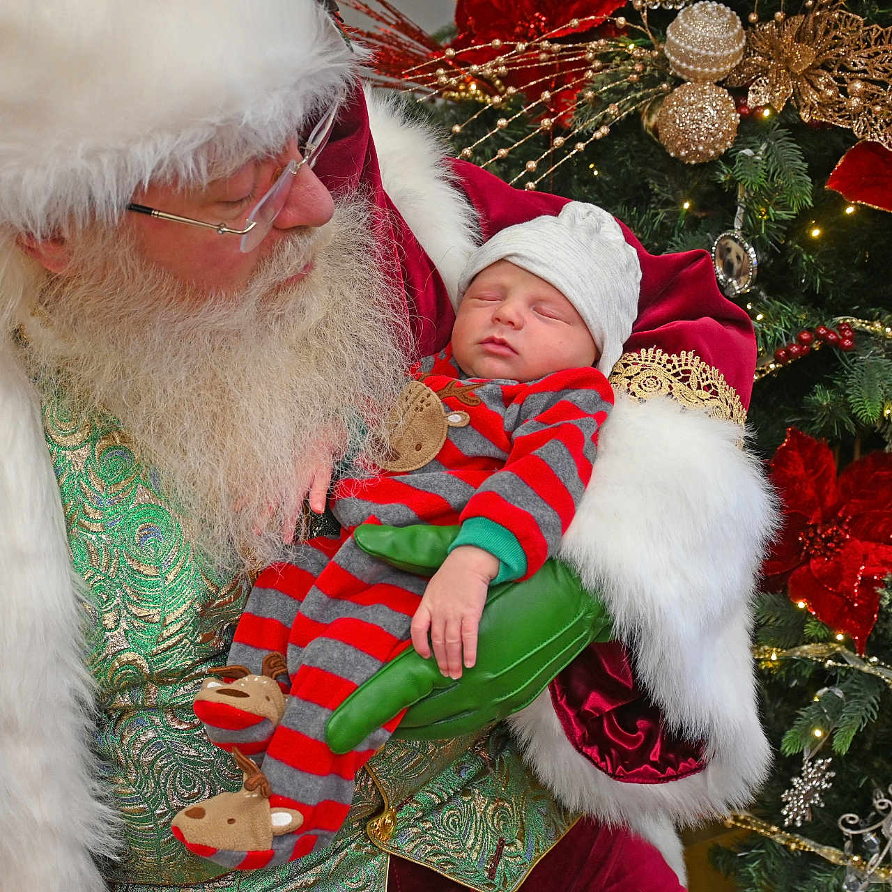 Carson is registered to the contest to win money with this photo: accessories, baby, beard, bonnet, christmas, christmasdecorations, christmastree, clothing, costume, doll, face, festival, glasses, hat, head, newborn, ornament, person, santaclaus, toy
