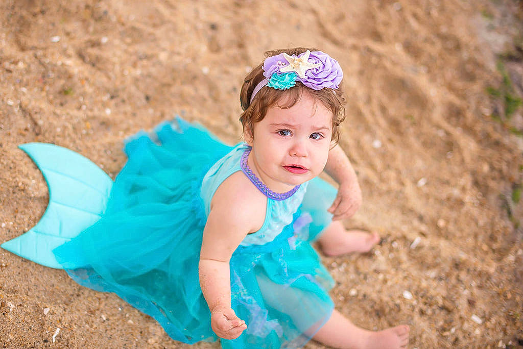 Shelby is registered to the contest to win money with this photo: aqua, azure, baby, baby_toddler_clothing, child, dress, electric_blue, face, flash_photography, fun, grass, happy, hat, headpiece, iris, people_in_nature, person, pink, sand, skin