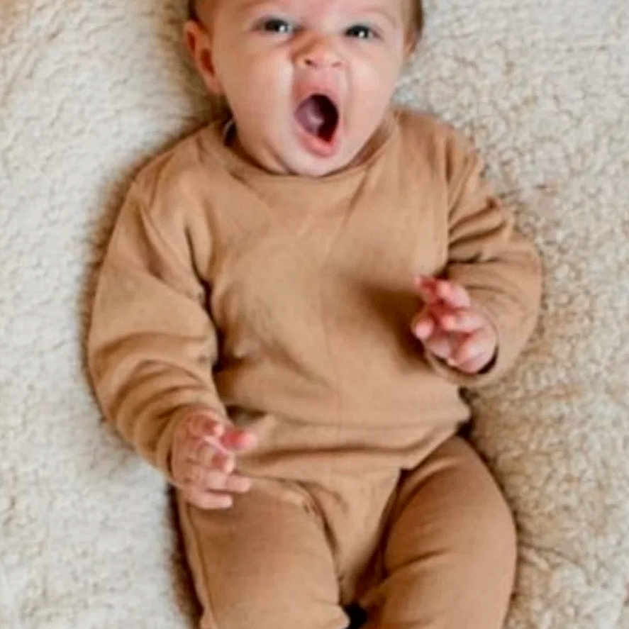 Antonio a rejoint le concours — aidez-le/la à gagner de superbes lots ! baby, blanket, brown_clothing, child, comfortable, cozy, cute, expression, face, feet, hands, indoor, infant, pajamas, person, portrait, sitting, soft_texture, yawn, young