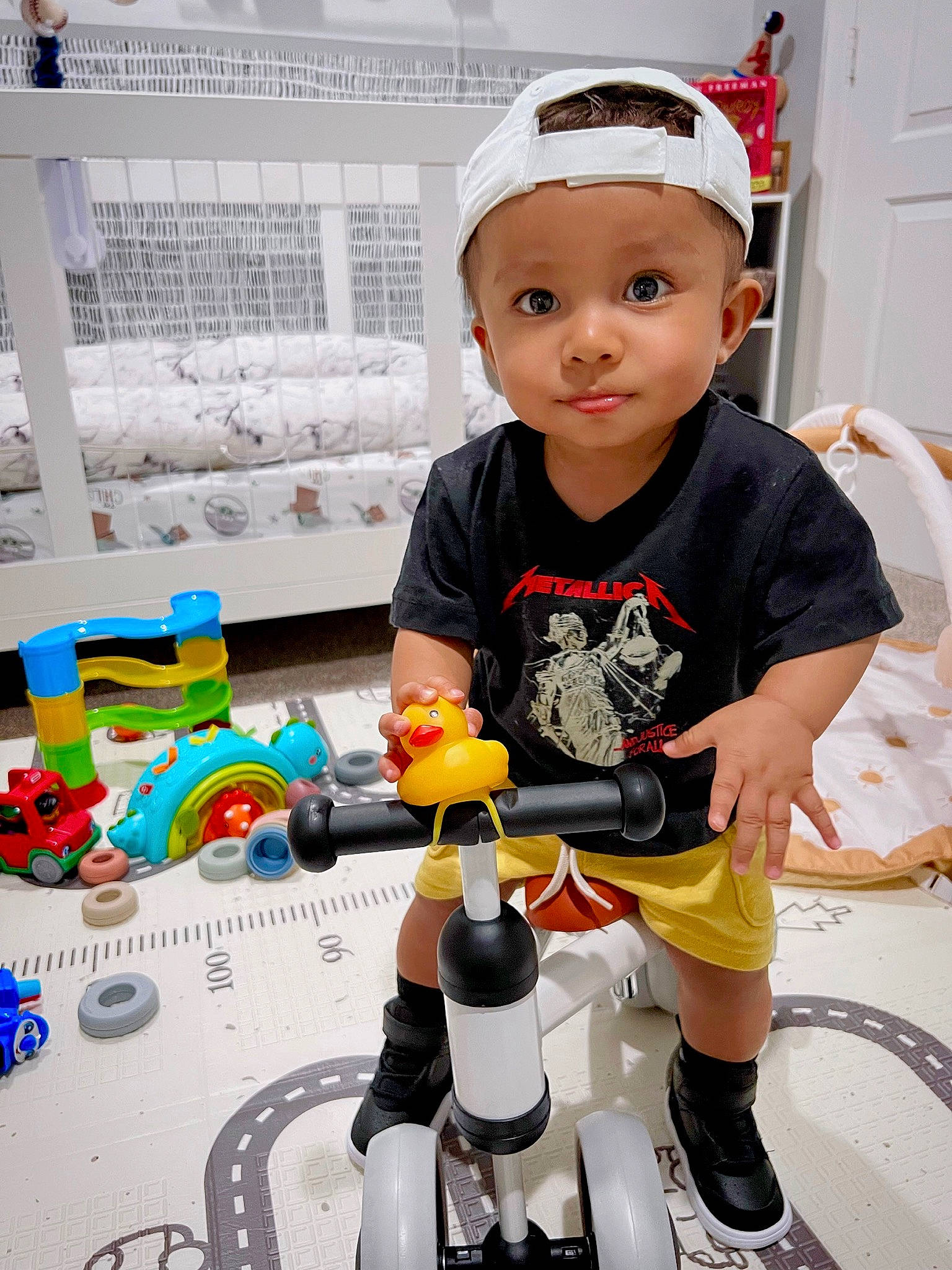 Keanu is registered to the contest to win money with this photo: automotive_tire, baby_toddler_clothing, cap, child, engineering, flooring, fun, headwear, lego, machine, person, product, rolling, shorts, sleeve, thigh, tire, toddler, toy, toy_block