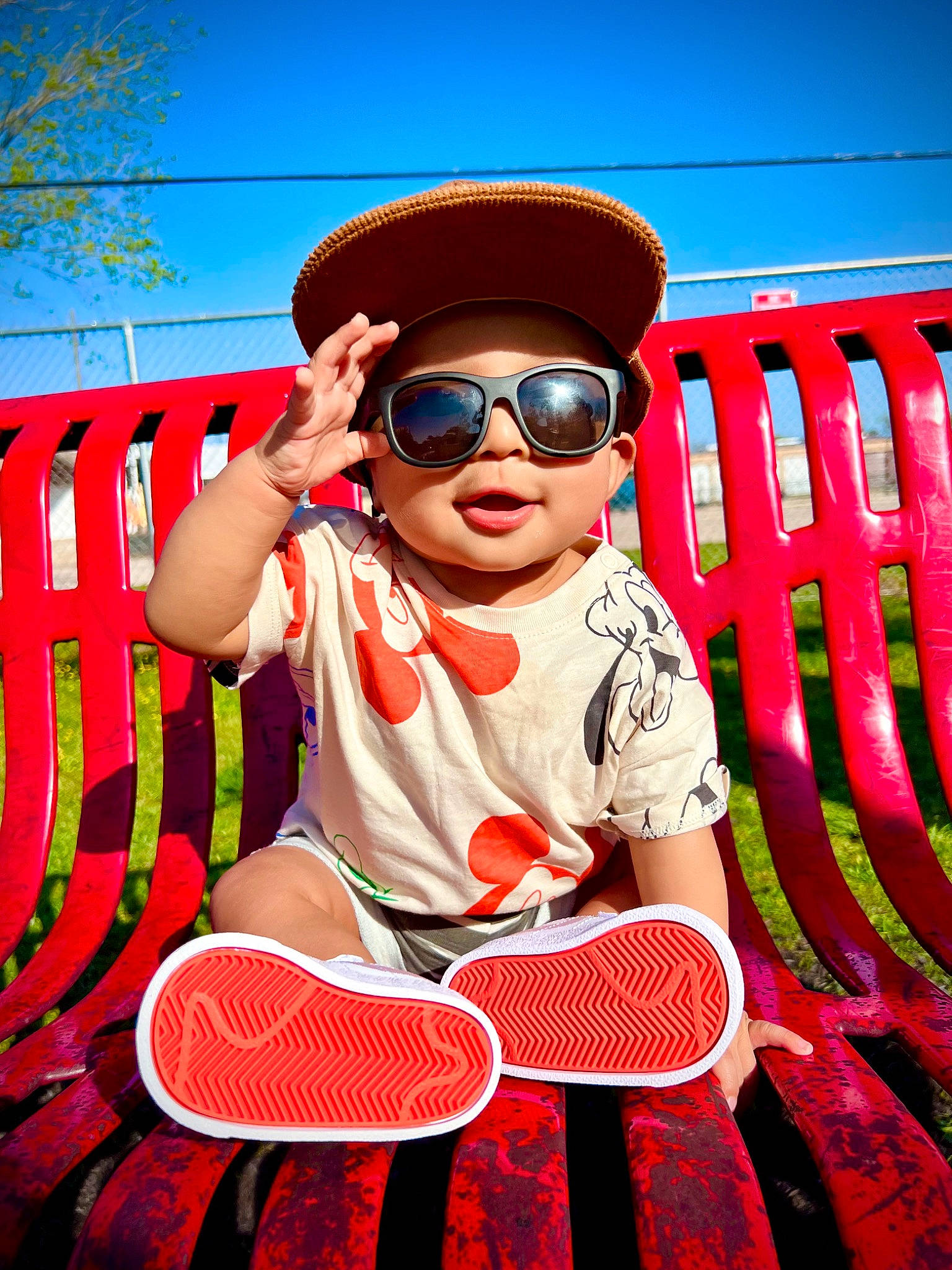 Keanu is registered to the contest to win money with this photo: baby_toddler_clothing, blue, cap, cool, eyewear, fun, glasses, goggles, grass, happy, hat, headwear, leisure, person, personal_protective_equipment, plant, red, sky, smile, sunglasses