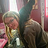 Morrie joined the competition — help win amazing prizes! animal, black_cat, blonde_hair, cage, casual_clothing, curtain, floor, furniture, glasses, home, indoor, light, painting, person, pet, portrait, shoulder, smile, window, woman