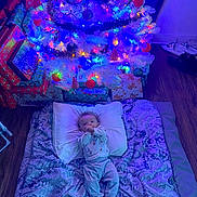 Michael is registered to the contest to win money with this photo: baby, bed, blanket, blue_lighting, child, christmas_lights, christmas_tree, colorful, cozy, family, festive, holiday, home, indoor, infant, ornaments, pillow, portrait, presents, sleeping