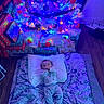 baby, bed, blanket, blue_lighting, child, christmas_lights, christmas_tree, colorful, cozy, family, festive, holiday, home, indoor, infant, ornaments, pillow, portrait, presents, sleeping