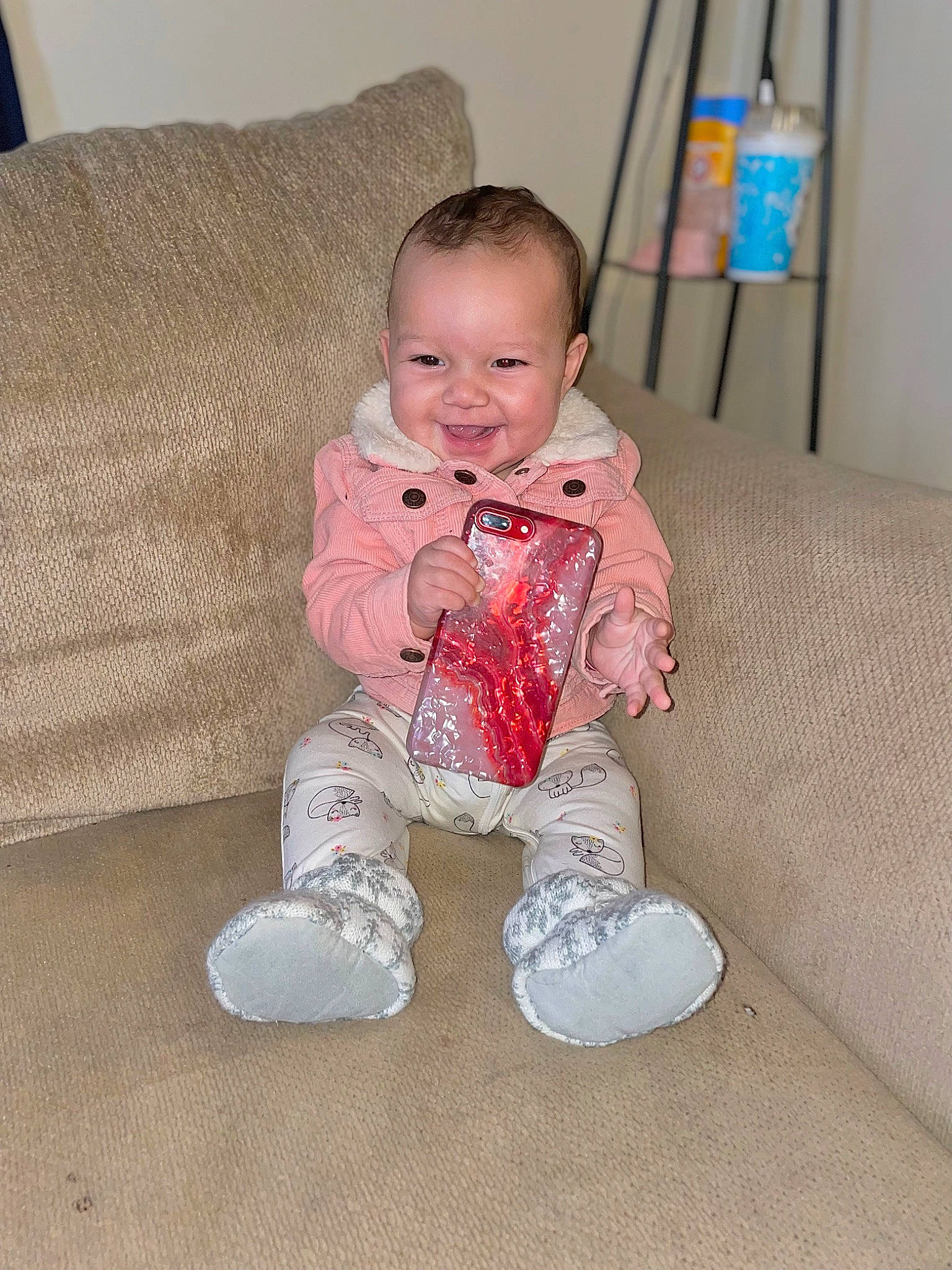 Kaylina is registered to the contest to win money with this photo: baby, baby_toddler_clothing, cheek, child, comfort, couch, face, floor, flooring, head, iris, joy, mammal, nose, outerwear, person, skin, sleeve, smile, standing