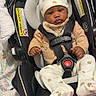 Corday is registered to the contest to win money with this photo: baby, infant, car_seat, hat, blanket, clothing, face, person, sitting, straps, cute, indoors, pattern, bear, footwear, child, comfort, safety, expression, cozy