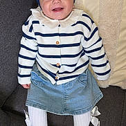 Andréa participe au concours pour gagner de l'argent avec cette photo : baby, infant, smile, headband, bow, striped_sweater, denim_skirt, tights, sneakers, couch, cushion, earrings, portrait, indoor, cozy, happy, fashion, cute, sitting, child