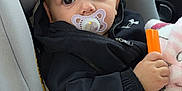 Andréa participe au concours pour gagner de l'argent avec cette photo : baby, infant, pacifier, car_seat, blanket, car_interior, jacket, hand, toy, eyes, face, portrait, seat, window, side_mirror, seat_padding, hood, pink_blanket, orange_object, cozy