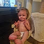 baby, cat_tree, child, cute, diaper, face, feet, furniture, hair_bun, hammock, hands, happy, home, indoor, person, sitting, smiling, soft_texture, television, toddler