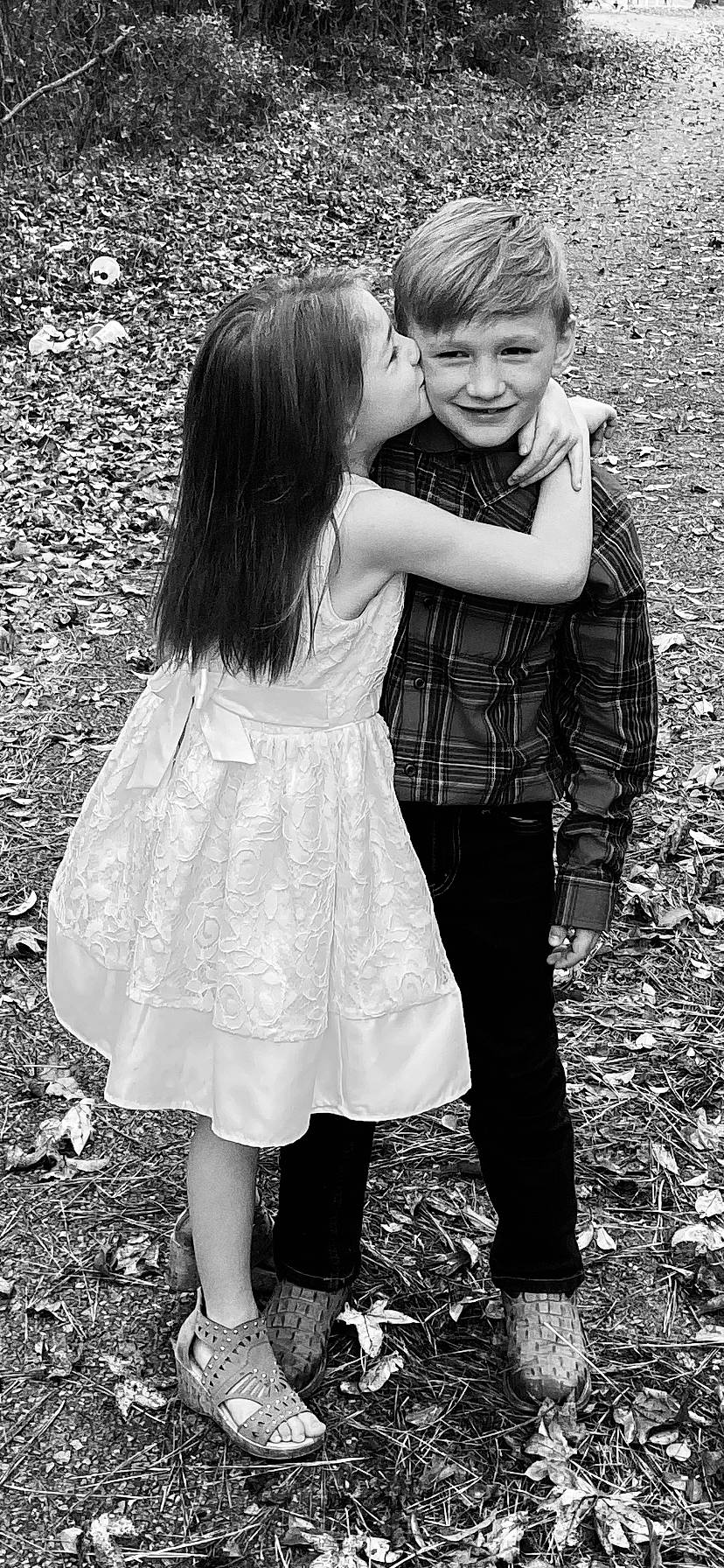Virginia is registered to the contest to win money with this photo: black, black_and_white, child, friendship, gesture, grass, happy, hug, interaction, joy, love, monochrome, monochrome_photography, people, person, photograph, photography, smile, snapshot, standing