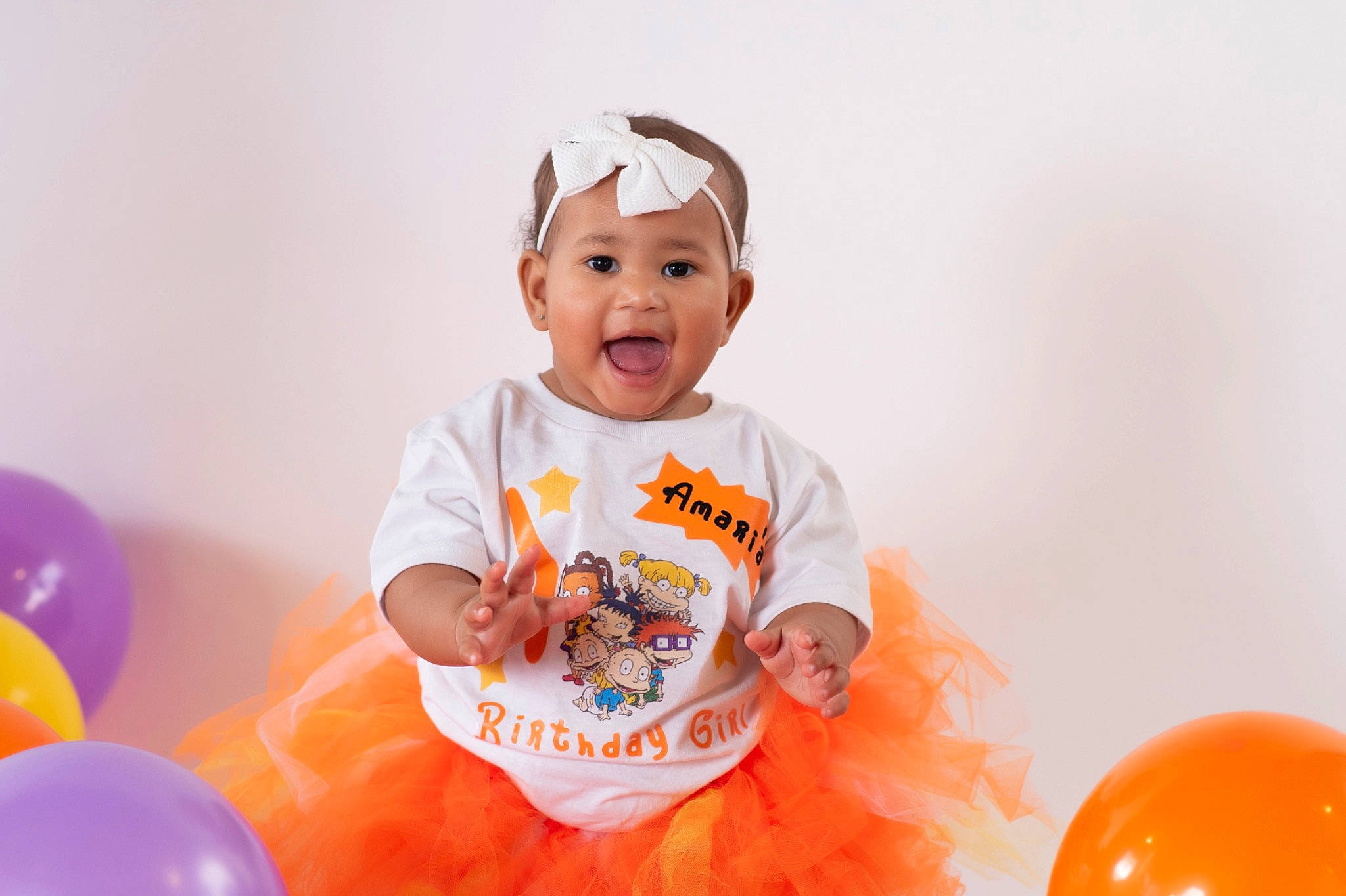 Amari'A joined the competition — help win amazing prizes! baby, baby_playing_with_toys, baby_toddler_clothing, balloon, child, event, facial_expression, fun, happy, headwear, leisure, orange, party, party_supply, peach, person, product, shorts, sleeve, smile