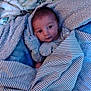 Emmett is registered to the contest to win money with this photo: baby, blanket, cozy, cute, face, infant, indoors, laying_down, looking, newborn, person, portrait, soft, striped, toddler, warm, wearing, wrapped, young, sleepwear