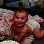 baby, diaper, crawling, playpen, mesh, blanket, toy, video_call, adult, smile, face, indoor, child, person, screen, technology, filter, happy, casual, communication
