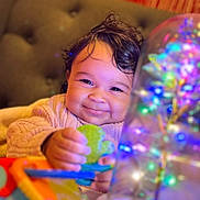 Esmeralda joined the competition — help win amazing prizes! baby, child, smile, toy, colorful, glowing, light, decorative, couch, cozy, indoor, happy, face, hand, clothing, warm, cute, portrait, infant, playtime