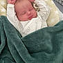 baby, sleeping, blanket, stars_pattern, green_blanket, infant, cozy, peaceful, soft_texture, bed, pajamas, cute, newborn, resting, comfort, child, face, hands, warm, indoors
