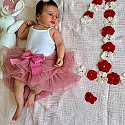 Selena participe au concours pour gagner de l'argent avec cette photo : baby, blanket, bow, celebration, cute, feet, flower_arrangement, hand, headband, infant, laying_down, milestone, pink_tutu, plush_toy, red_flowers, skin, soft_texture, white_bunny, white_flowers, white_tank_top