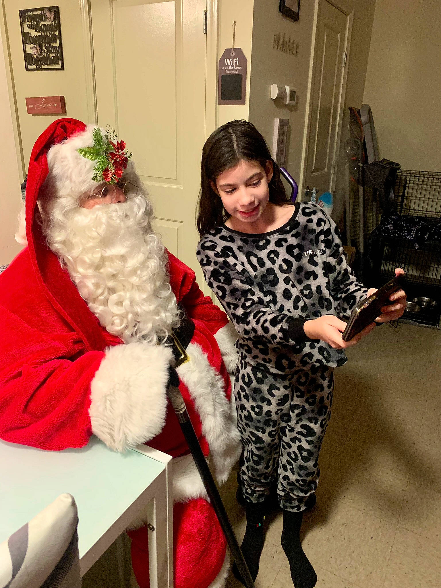 Nevaeh is registered to the contest to win money with this photo: beard, facial_expression, fur_clothing, furniture, hair, hairstyle, happy, hat, human_body, jacket, joy, lap, leg, outerwear, person, santa_claus, shoe, smile, standing, table