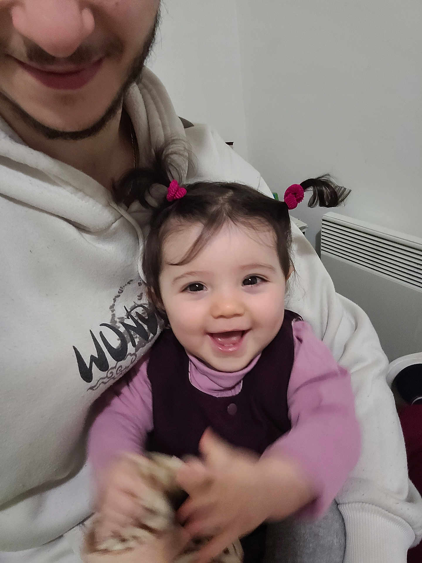 Julia participe au concours pour gagner de l'argent avec cette photo : baby, child, smiling, pigtails, hair_ties, adult, hoodie, sweater, holding, hands, playful, indoor, radiator, face, portrait, cute, happy, eyes, mouth, blanket
