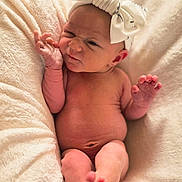 Delilah joined the competition — help win amazing prizes! baby, newborn, infant, blanket, bow, headwear, skin, foot, hand, expression, face, wrinkle, cute, sleepwear, soft, cozy, lying_down, indoors, portrait, human