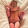 baby, newborn, infant, blanket, bow, headwear, skin, foot, hand, expression, face, wrinkle, cute, sleepwear, soft, cozy, lying_down, indoors, portrait, human