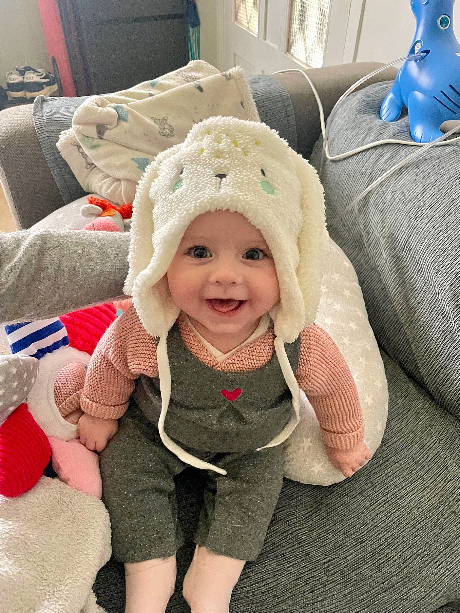 Victoire participe au concours pour gagner de l'argent avec cette photo : baby, baby_products, baby_toddler_clothing, beanie, cap, child, comfort, fashion_accessory, flooring, fun, happy, headwear, joy, knit_cap, linens, pattern, person, room, sitting, skin