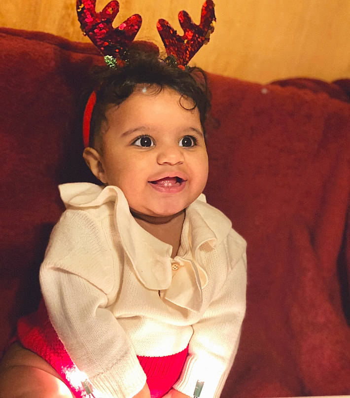 Jordynn is registered to the contest to win money with this photo: baby, baby_toddler_clothing, costume, costume_accessory, couch, hair_accessory, headband, headpiece, living_room, mouth, person, pleased, toddler