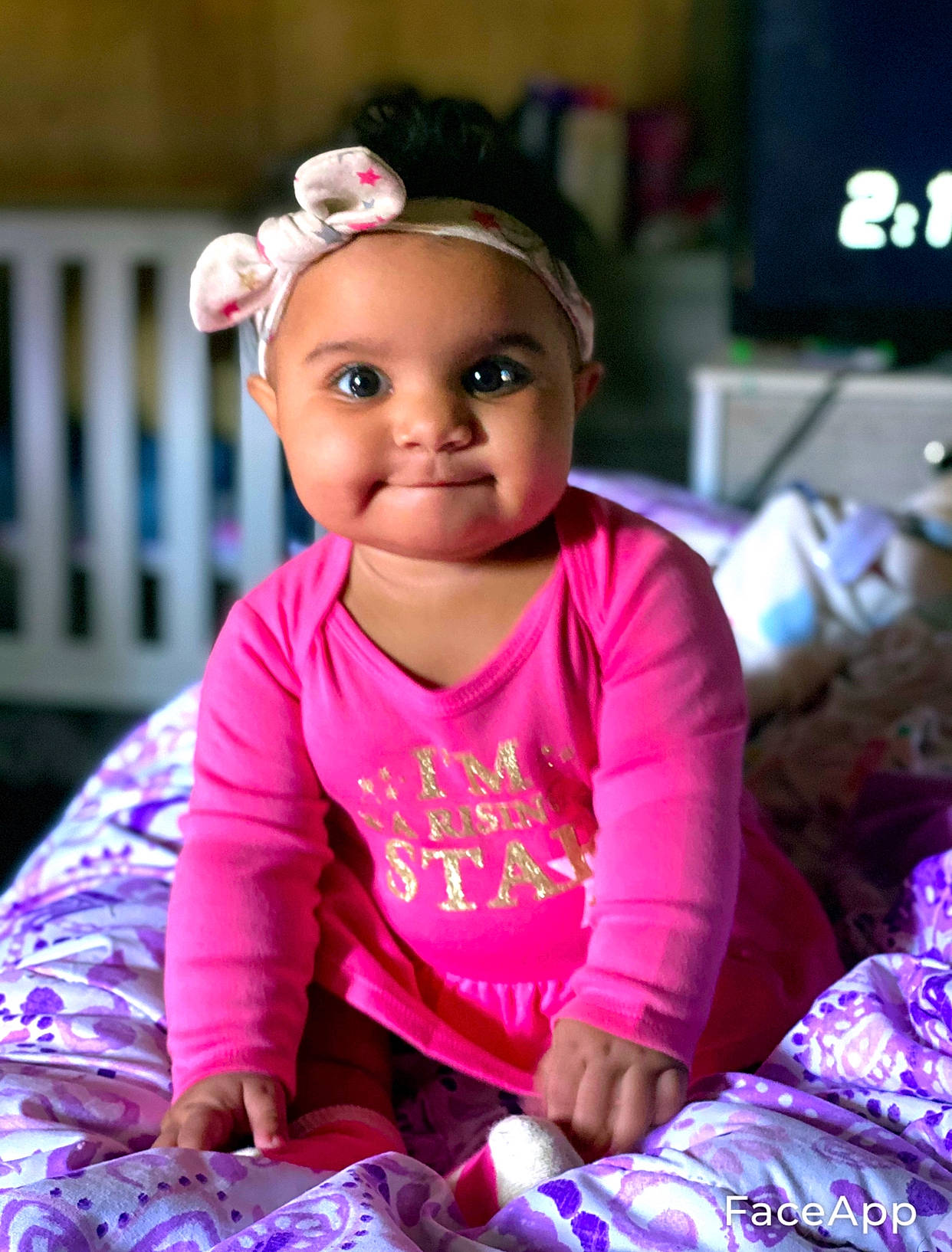 Jordynn is registered to the contest to win money with this photo: baby, baby_products, baby_toddler_clothing, child, hair_accessory, headband, headpiece, headwear, joy, nightwear, person, pink, sitting, toddler