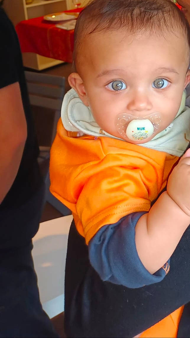 Raphaël participe au concours pour gagner de l'argent avec cette photo : baby, baby_toddler_clothing, cheek, chin, eye, eyebrow, face, finger, fun, happy, iris, lip, mouth, nose, orange, person, sitting, skin, sleeve, t_shirt