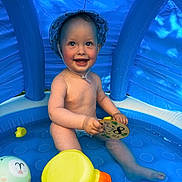 Markas is registered to the contest to win money with this photo: baby, child, smiling, blue_pool, inflatable_pool, water, toy, hat, summer, outdoor, cute, happy, skin, sitting, playtime, infant, sun_hat, plastic_toy, childhood, portrait