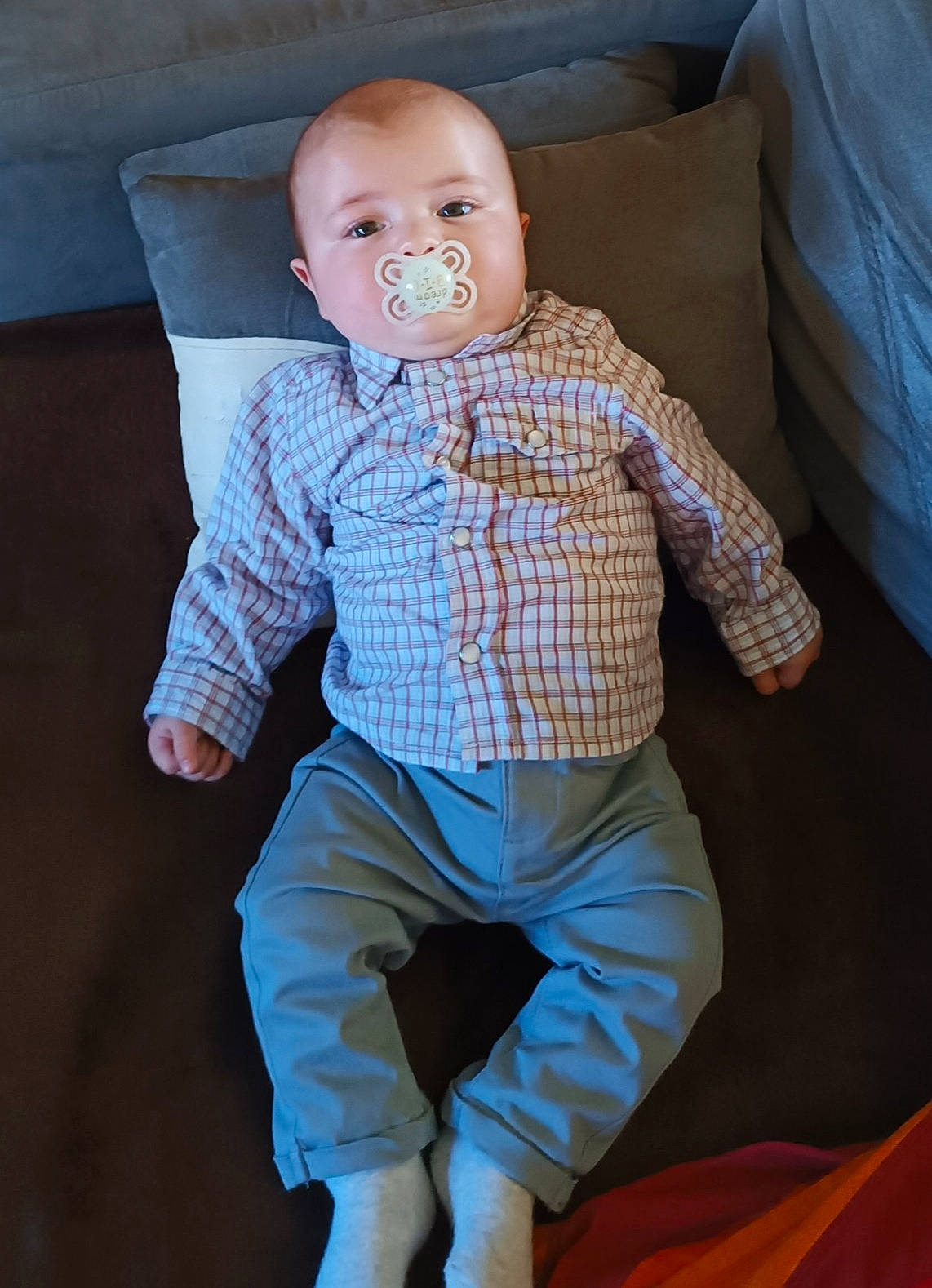 Naël participe au concours pour gagner de l'argent avec cette photo : baby, baby_toddler_clothing, cheek, child, chin, comfort, couch, dress_shirt, eye, face, gesture, hand, head, leg, linens, neck, nose, person, sleeve, toddler