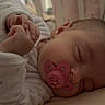 baby, sleeping, pacifier, crib, hands, infant, cozy, soft_lighting, peaceful, child, bed, pajamas, indoor, cute, rest, portrait, close_up, fingers, young, calm