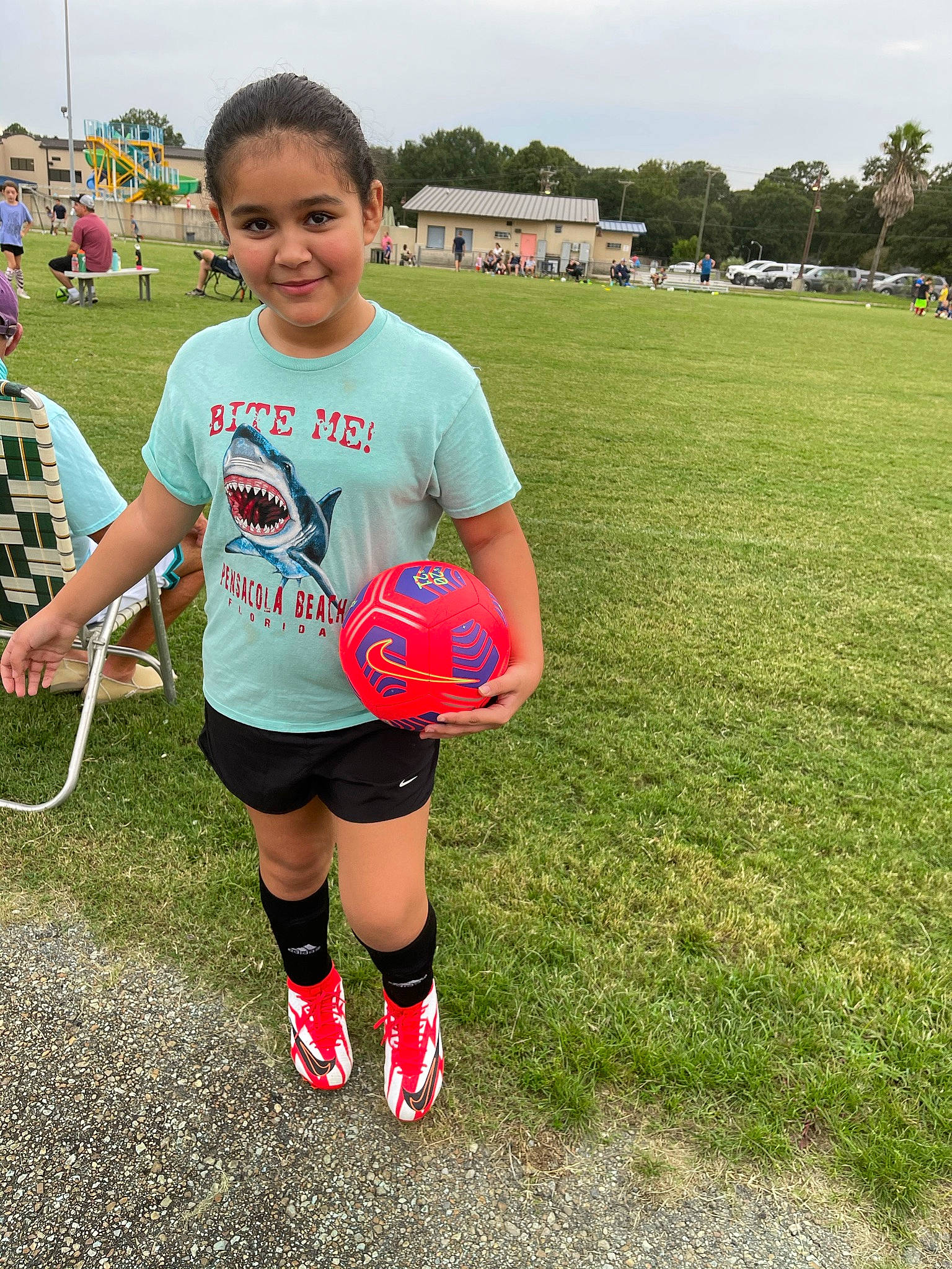 Victoria is registered to the contest to win money with this photo: ball, ball_game, competition_event, fun, grass, joy, knee, leisure, person, player, recreation, shoe, shorts, sky, smile, sneakers, soccer_ball, sports, sports_equipment, sportswear