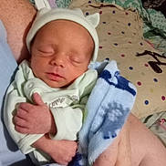 Jared is registered to the contest to win money with this photo: newborn, baby, infant, sleeping, hat, blanket, arm, hand, bed, pillow, polka_dot, clothing, person, indoor, rest, soft, cute, cozy, sleep, peaceful