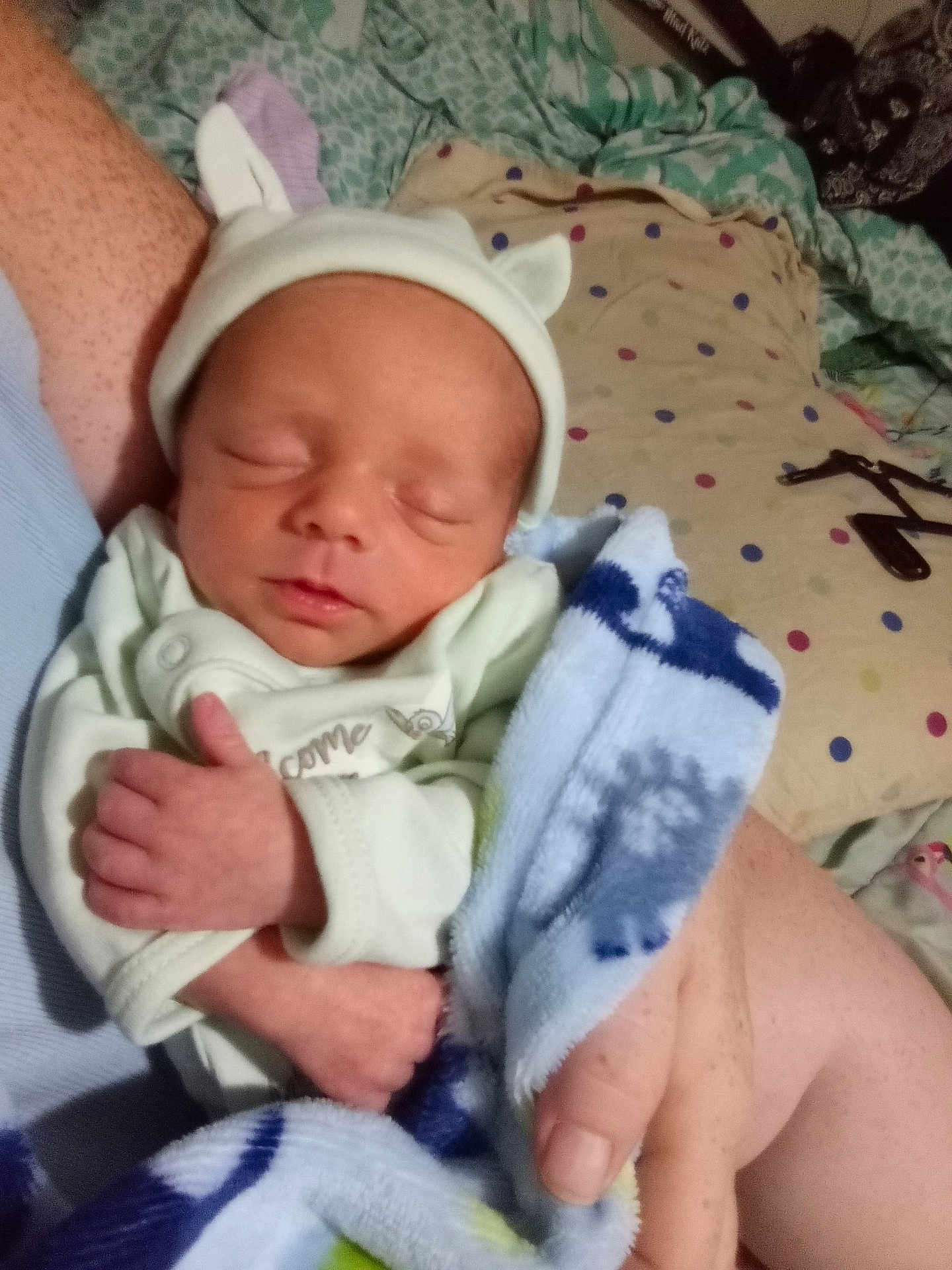Jared is registered to the contest to win money with this photo: newborn, baby, infant, sleeping, hat, blanket, arm, hand, bed, pillow, polka_dot, clothing, person, indoor, rest, soft, cute, cozy, sleep, peaceful