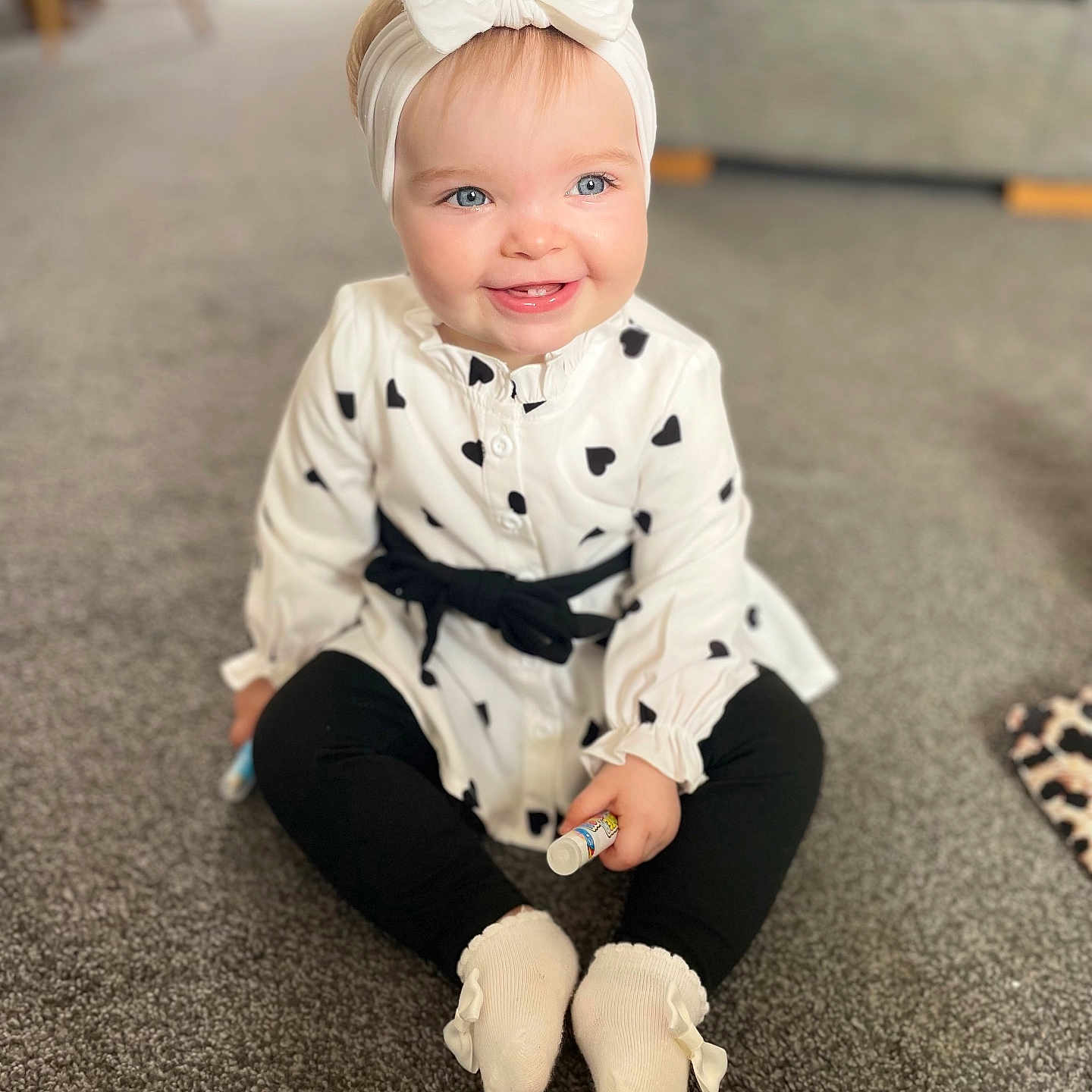 Sophia joined the competition — help win amazing prizes! baby, black_hearts, black_leggings, blue_eyes, bow, carpet, child, cozy, cute, girl, happy, headband, indoor, person, portrait, sitting, smiling, socks, toy, white_dress