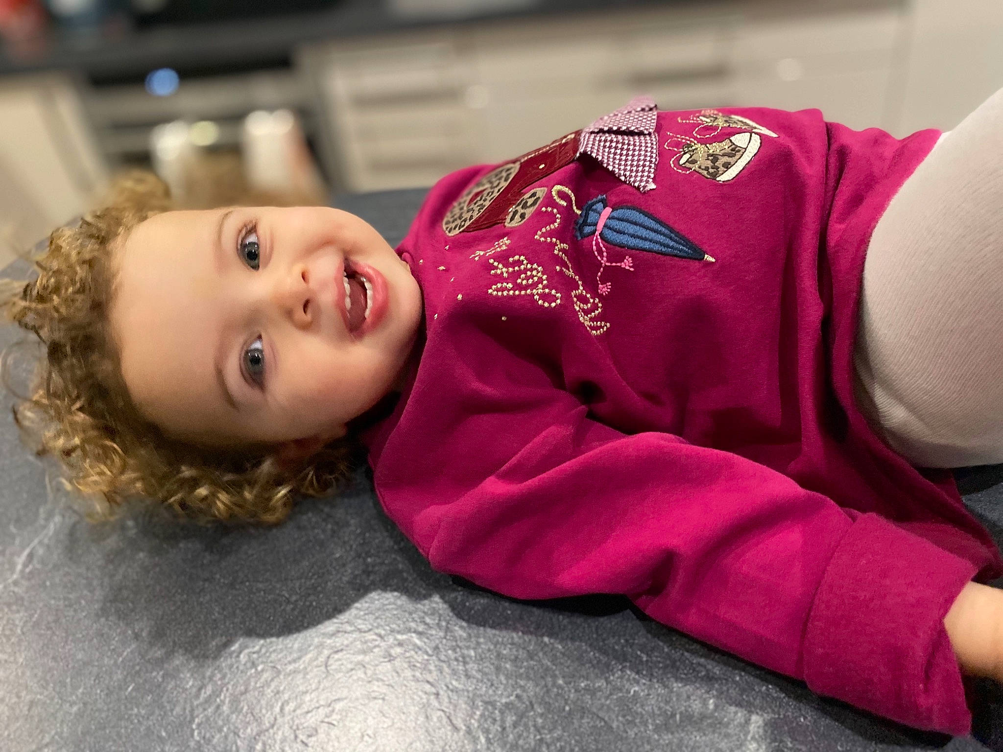 élyna a rejoint le concours — aidez-le/la à gagner de superbes lots ! baby, baby_toddler_clothing, carmine, cheek, child, flooring, fun, fur, happy, magenta, person, portrait_photography, room, sitting, sleeve, smile, toddler, tradition