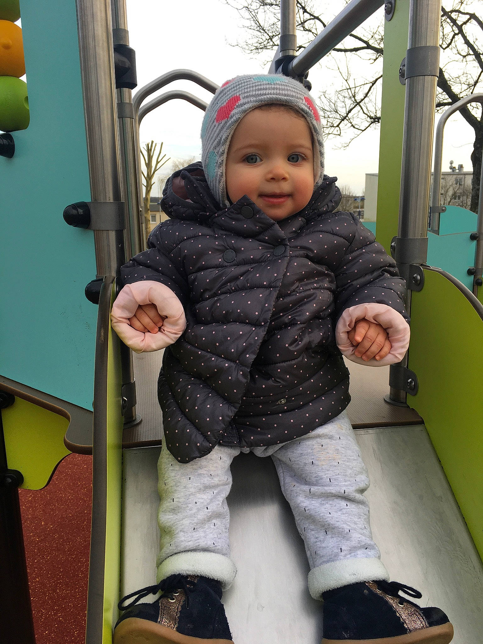 élyna participe au concours pour gagner de l'argent avec cette photo : baby, baby_toddler_clothing, bag, child, facial_expression, fun, happy, headwear, jacket, leisure, outerwear, person, playground, skin, sleeve, sneakers, standing, street_fashion, thigh, toddler