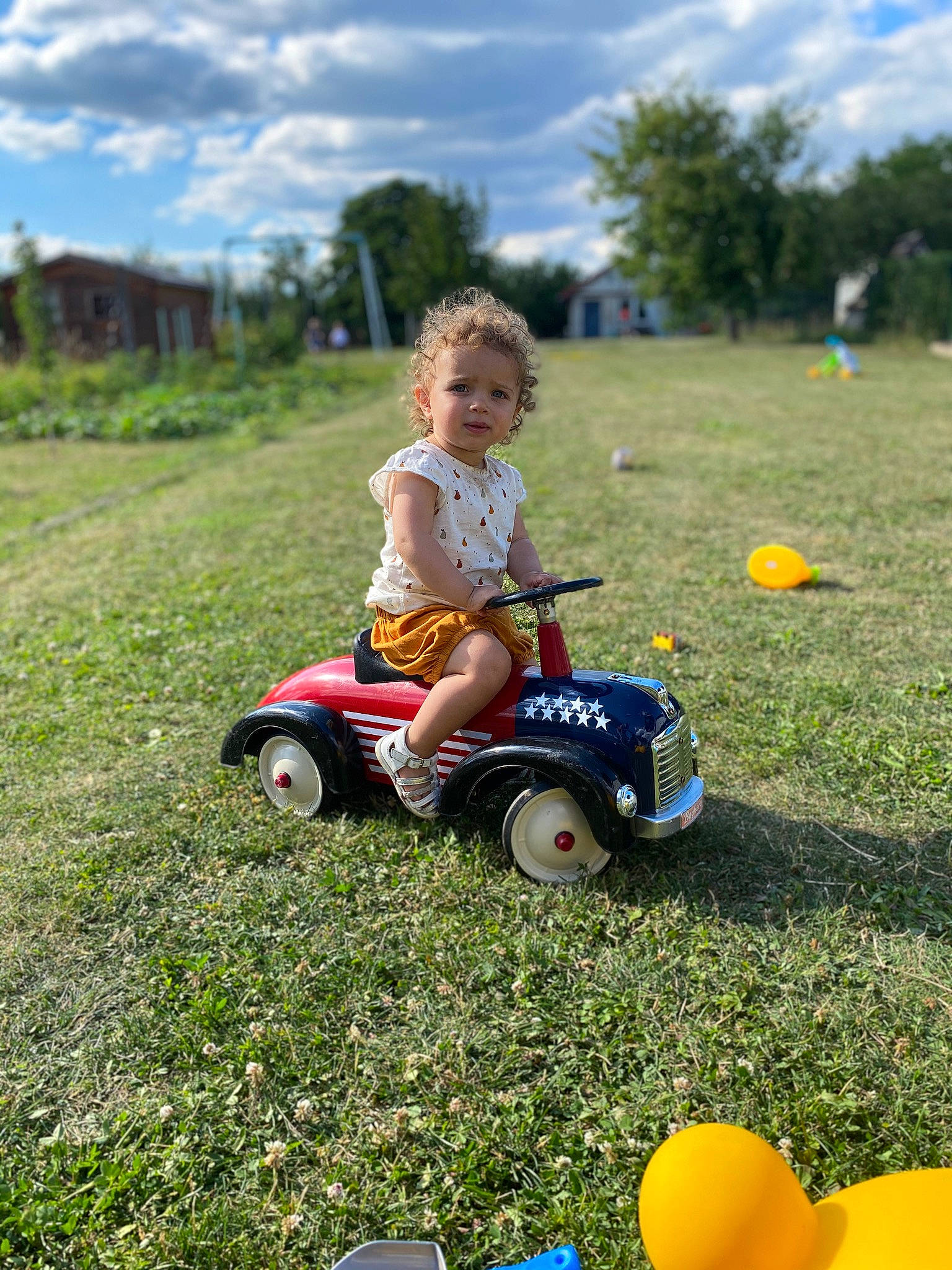 élyna a rejoint le concours — aidez-le/la à gagner de superbes lots ! automotive_tire, cloud, fun, grass, grassland, happy, leisure, natural_environment, nature, people_in_nature, person, plant, playing_with_kids, riding_toy, sky, sunlight, tire, tree, vehicle, wheel