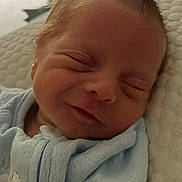 Brouks is registered to the contest to win money with this photo: baby, newborn, sleeping, smiling, blanket, blue, face, infant, soft, cute, peaceful, closeup, portrait, indoors, child, resting, skin, head, baby_clothes, cozy