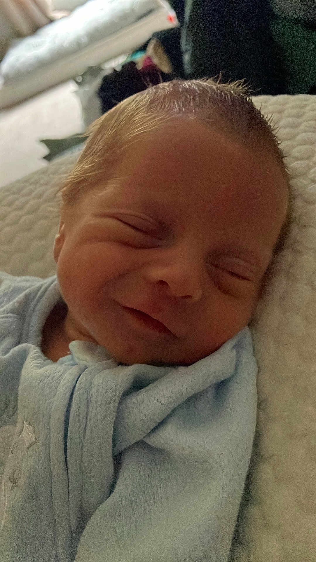 Brouks is registered to the contest to win money with this photo: baby, newborn, sleeping, smiling, blanket, blue, face, infant, soft, cute, peaceful, closeup, portrait, indoors, child, resting, skin, head, baby_clothes, cozy