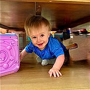 Hudson Paul Wood is registered to the contest to win money with this photo: toddler, child, blue_shirt, crawling, smiling, toy, pink_toy, wooden_table, indoor, floor, playtime, happy, young_child, person, cute, baby, hands, feet, face, home