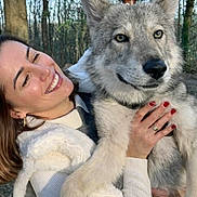 Napoli a rejoint le concours — aidez-le/la à gagner de superbes lots ! woman, dog, wolf_like_dog, smiling, outdoor, forest, trees, nature, daylight, happy, pet, holding, fur, animal, portrait, casual_clothing, red_nails, tree_trunk, human, friendship