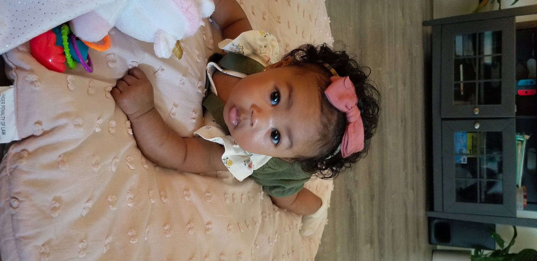 Yuna is registered to the contest to win money with this photo: baby, baby_toddler_clothing, cheek, child, comfort, dress, eyebrow, flooring, fun, happy, iris, linens, mouth, nose, person, picture_frame, pink, skin, smile, surprise