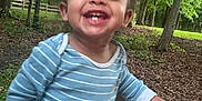 Meeko is registered to the contest to win money with this photo: child, toddler, smiling, outdoor, park, bench, trees, forest, greenery, happy, person, nature, daylight, casual_clothing, baby, grass, wood, joy, playful, cute