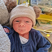 Julyan participe au concours pour gagner de l'argent avec cette photo : newborn, baby, hat, pom_poms, blue_clothing, blanket, infant, face, portrait, indoors, soft_texture, person, cute, cozy, young_child, warm_clothing, expression, hand, headwear, resting