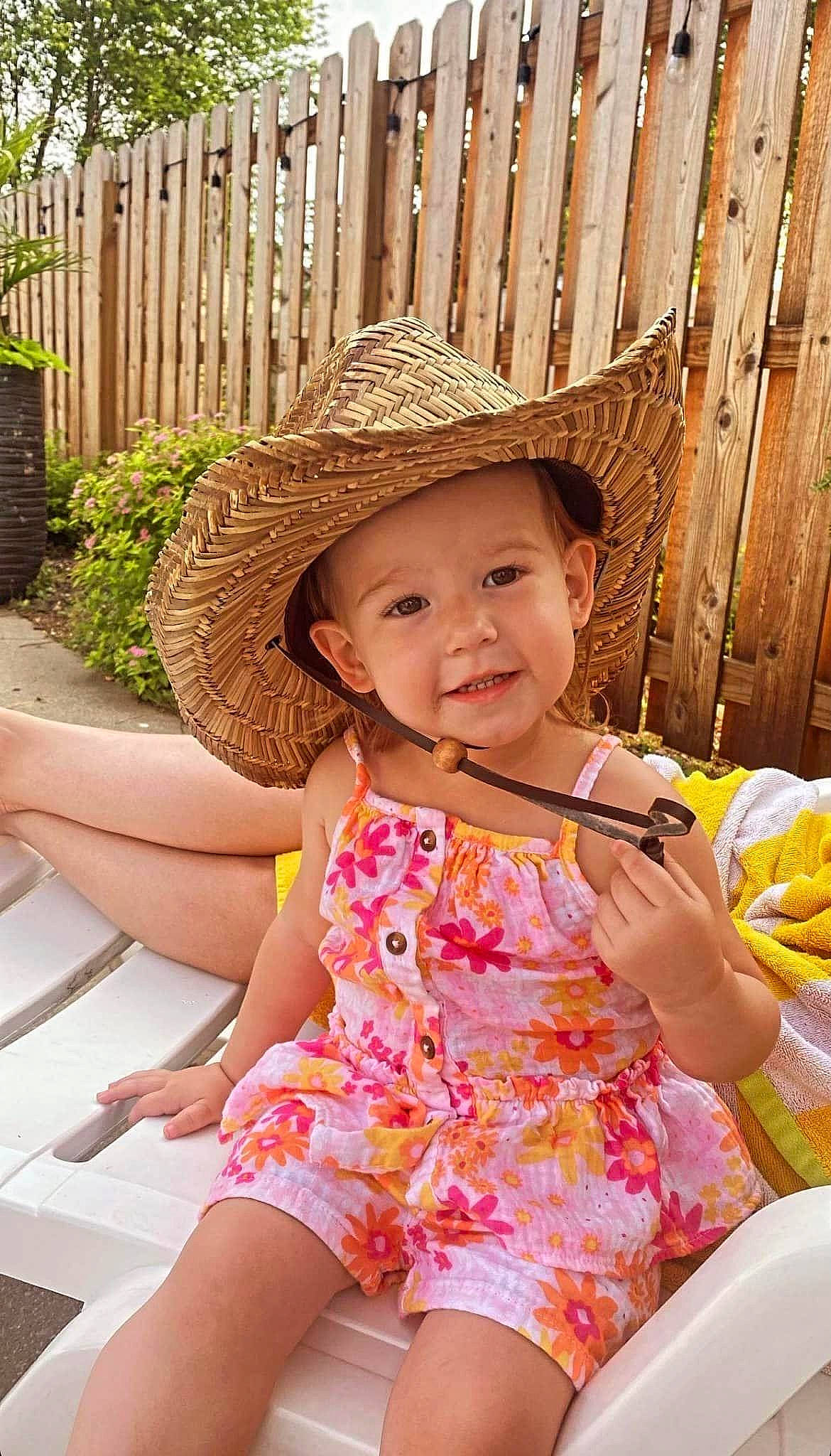 Saige is registered to the contest to win money with this photo: baby_toddler_clothing, beauty, child, fun, grass, happy, hat, headwear, human_leg, joy, leisure, person, photograph, pink, plant, recreation, sitting, skin, smile, summer