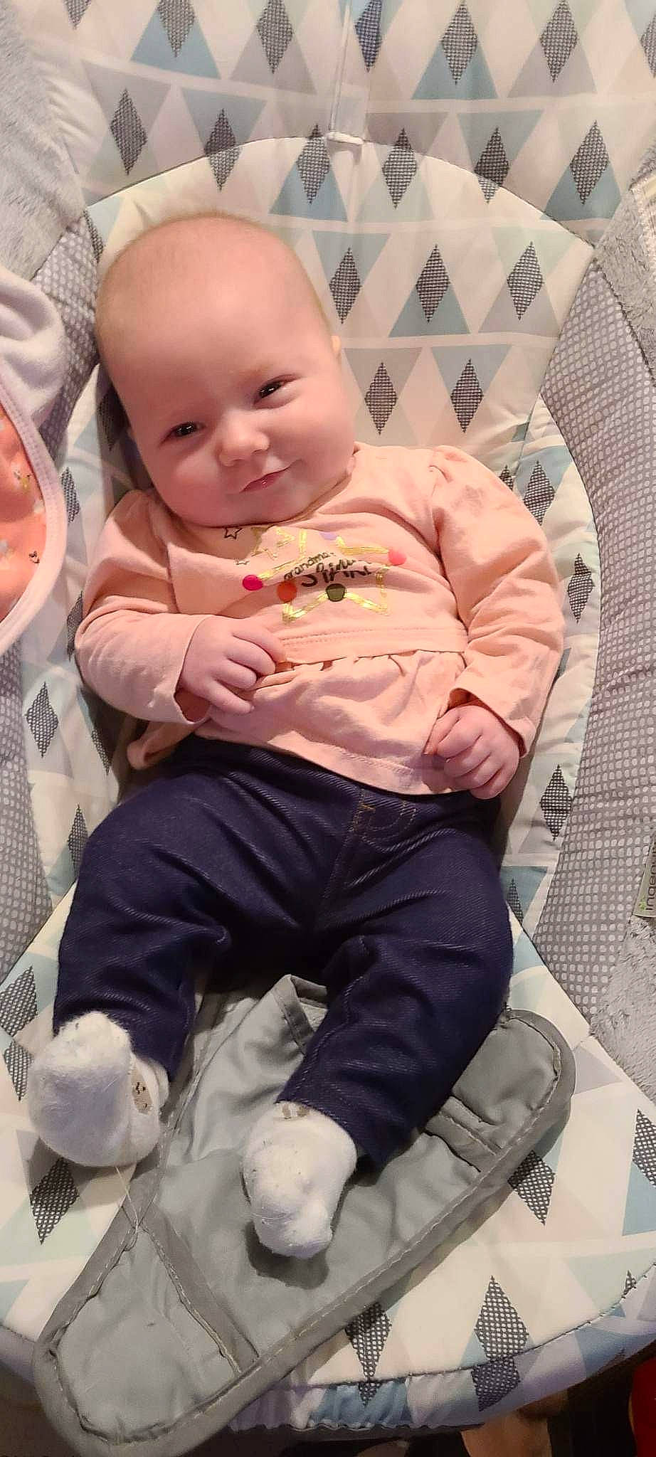 Raelynn is registered to the contest to win money with this photo: baby, baby_products, baby_toddler_clothing, cheek, child, comfort, facial_expression, fun, hairstyle, happy, head, lap, leg, mouth, person, pink, sitting, skin, sleeve, smile