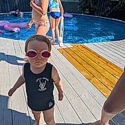 Iyla is registered to the contest to win money with this photo: toddler, child, swimming_pool, goggles, swimsuit, deck, sunlight, water, summer, outdoor, barefoot, play, kids, fun, family, vacation, blue, people, pool_toy, fence