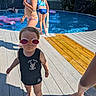 toddler, child, swimming_pool, goggles, swimsuit, deck, sunlight, water, summer, outdoor, barefoot, play, kids, fun, family, vacation, blue, people, pool_toy, fence