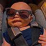 baby, child, sunglasses, car_seat, straps, blue_shirt, infant, seatbelt, cute, portrait, baby_face, indoor, child_safety, comfort, baby_hand, fashion, infant_clothing, headwear, accessory, seat